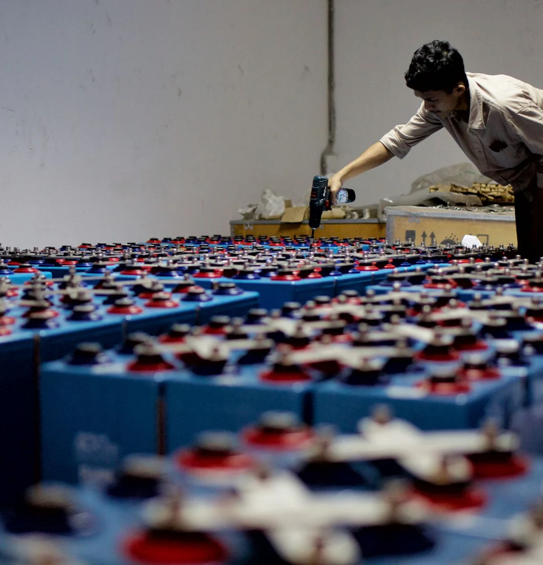 Rows of industrial backup batteries being inspected